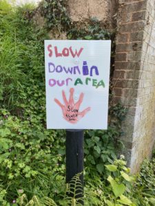 Children's slow down in our area painted sign